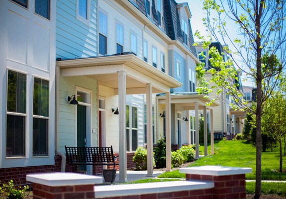 a row of houses with a lawn and trees