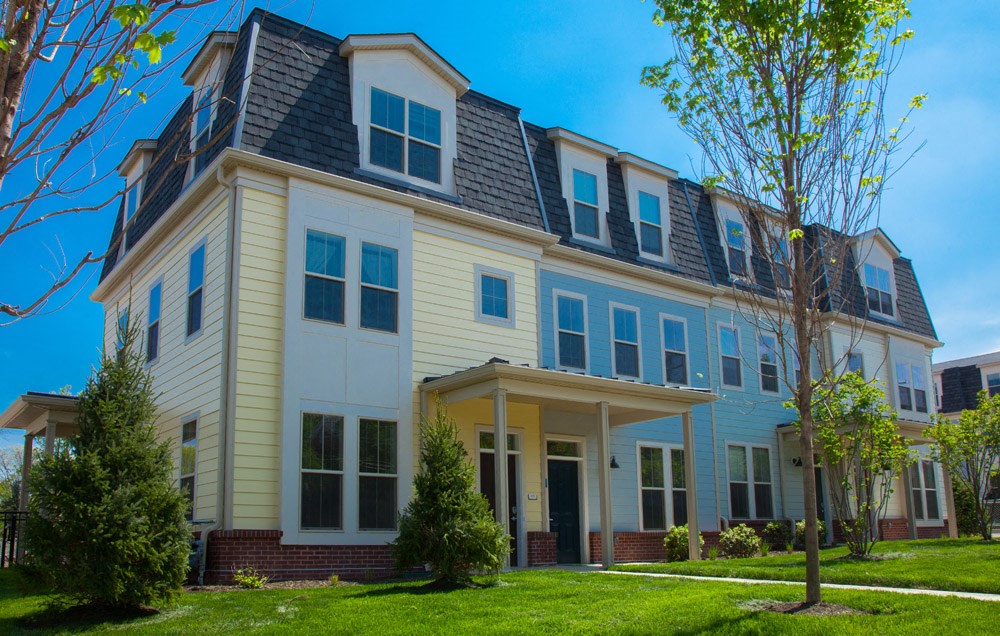 a large house with a lawn and trees in front of it