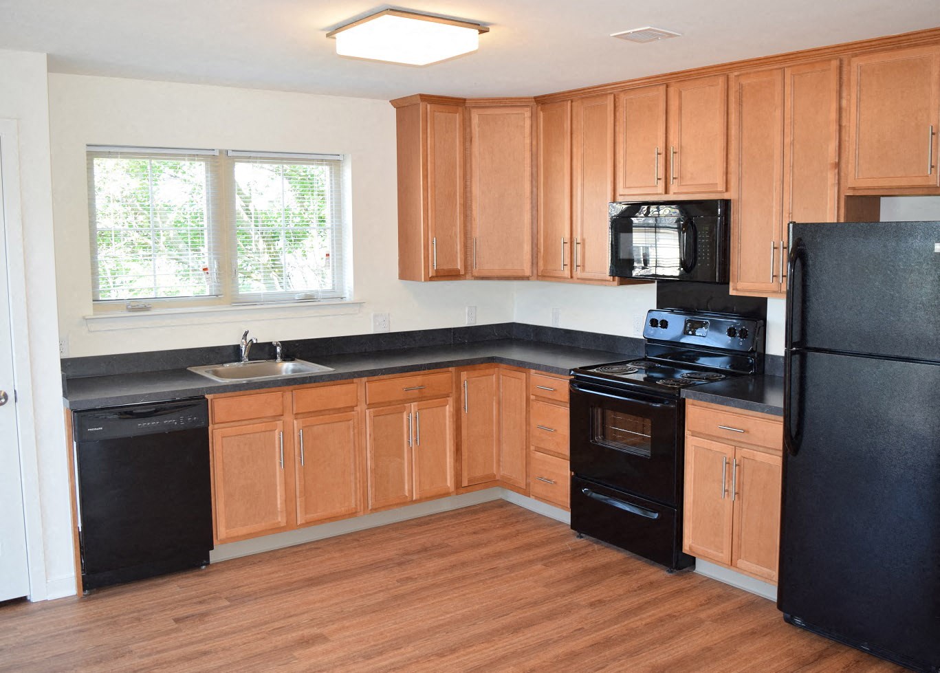 a kitchen with black appliances and wooden cabinets