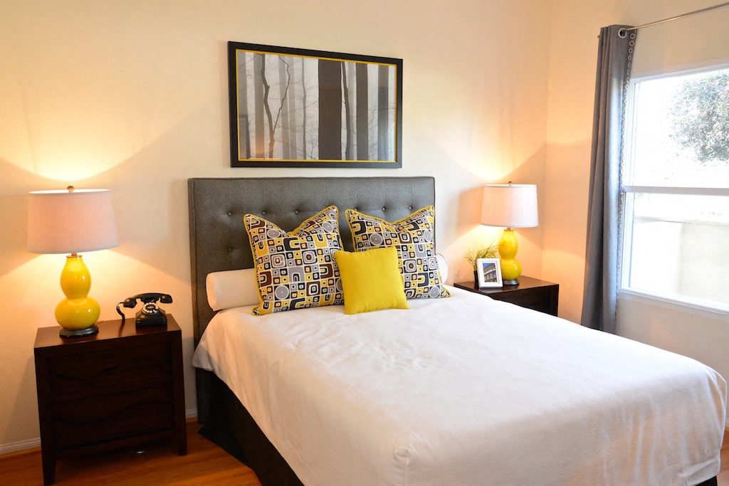 a bedroom with a white bed and yellow pillows