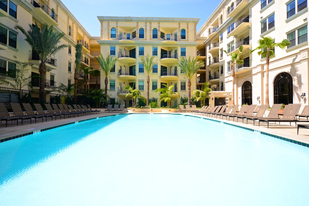 a large swimming pool in front of an apartment building