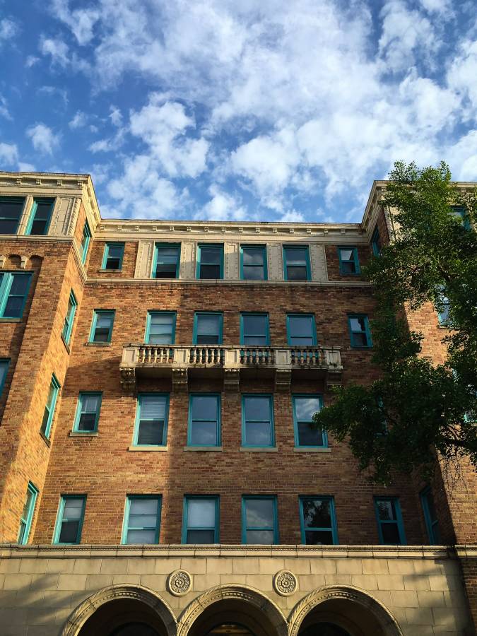 a tall brick building with a cloudy sky in the background