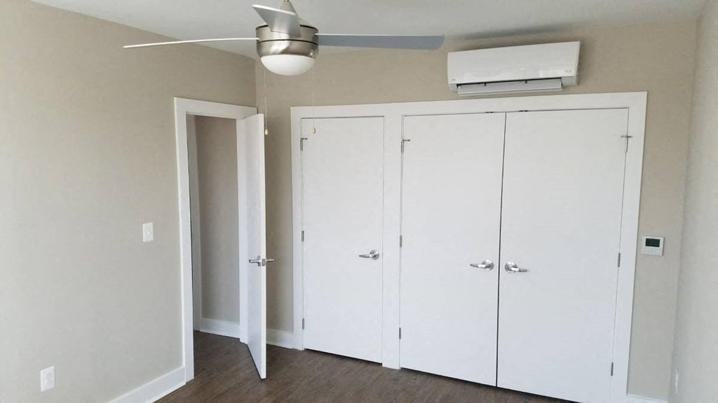 an empty room with white cabinets and a ceiling fan