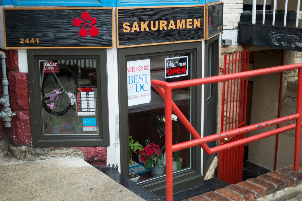 a small restaurant with a sign in the window that says best dog