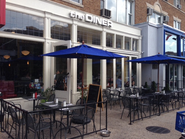a patio with tables and umbrellas outside of the diner