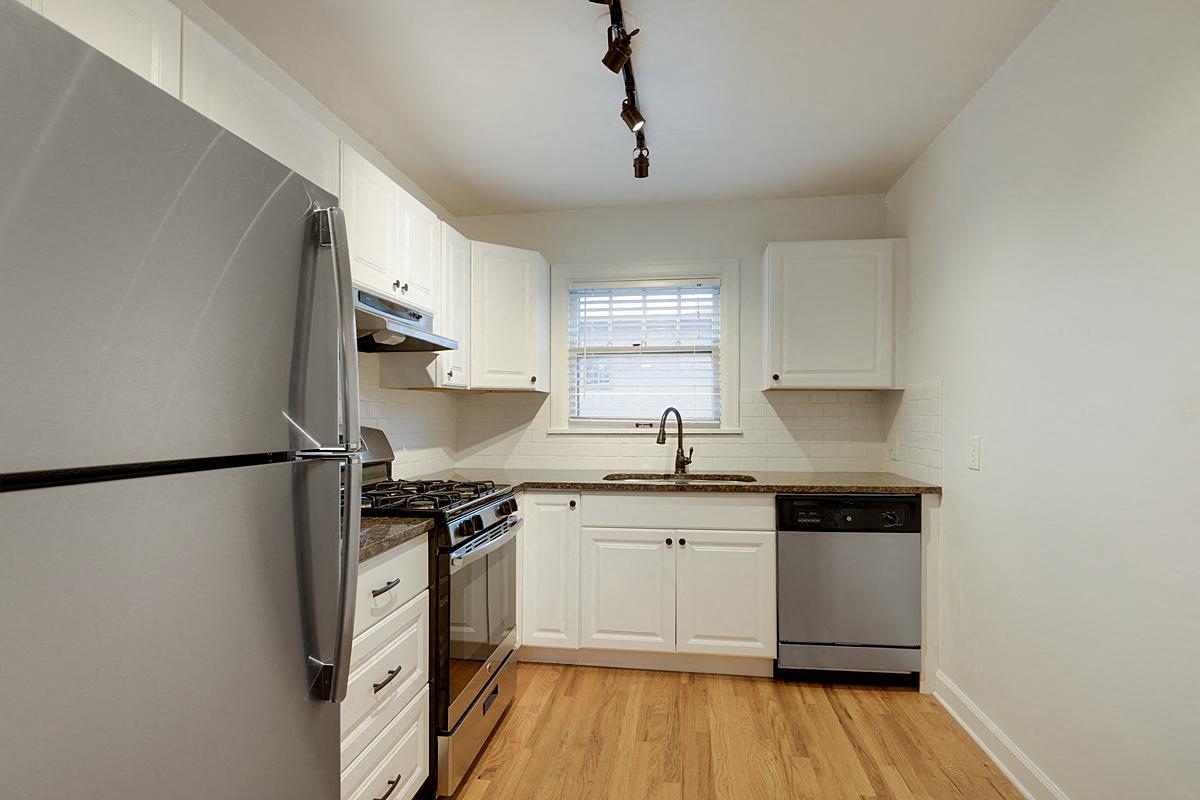 a kitchen with stainless steel appliances and white cabinets