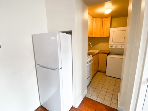 an empty kitchen with a refrigerator and a washing machine