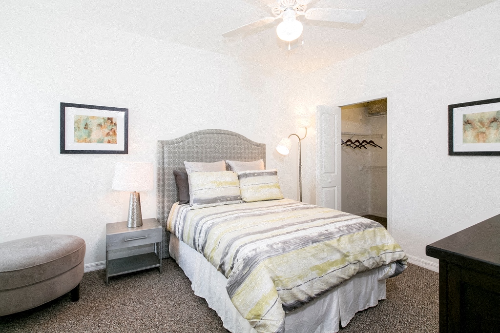 a bedroom with a bed and a ceiling fan