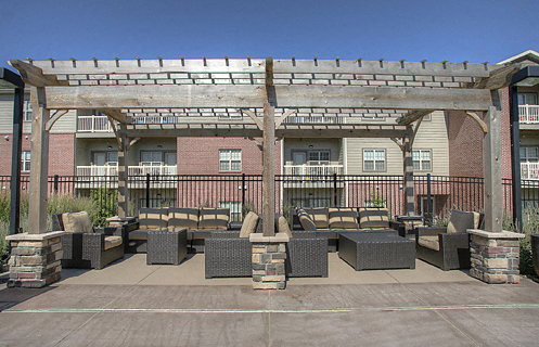 an outdoor patio with tables and chairs in front of an apartment building