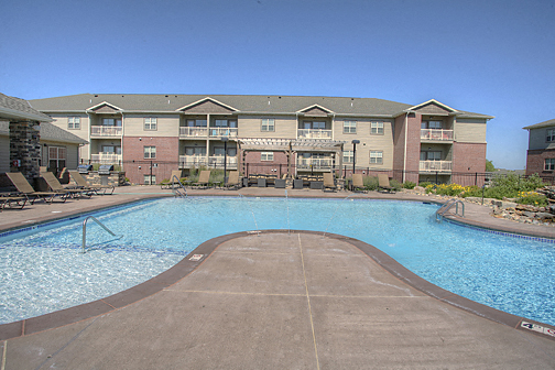 a swimming pool with an apartment building in the background