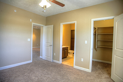 an empty living room with a closet and a bathroom