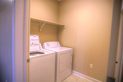an empty laundry room with a washer and dryer in it