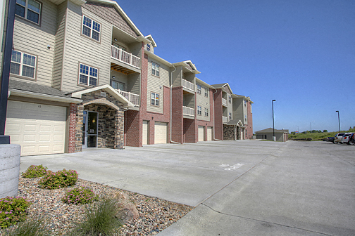 an empty parking lot in front of an apartment building