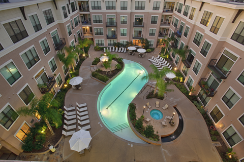 an overhead view of a large apartment building with a swimming pool