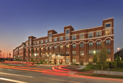 a large brick building at night with a street in front