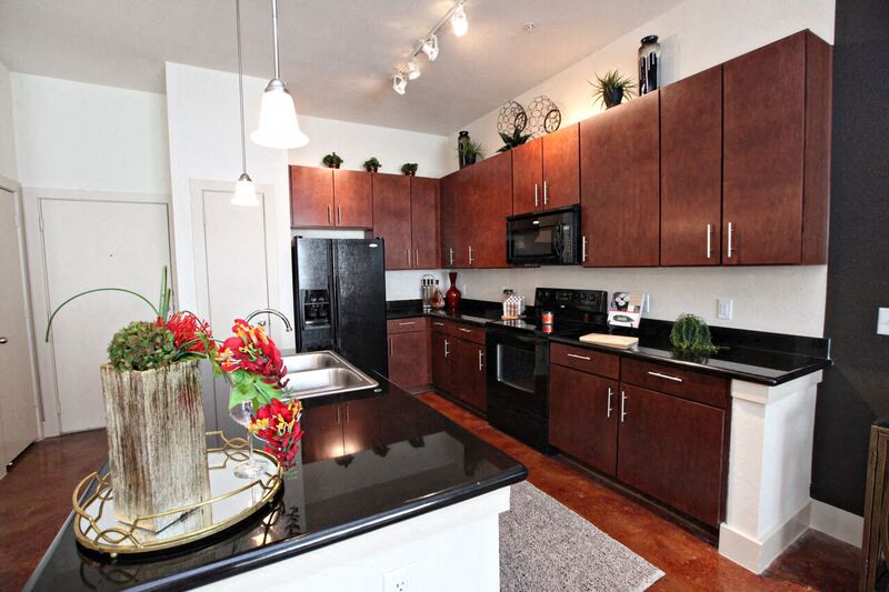 a kitchen with wooden cabinets and a black counter top