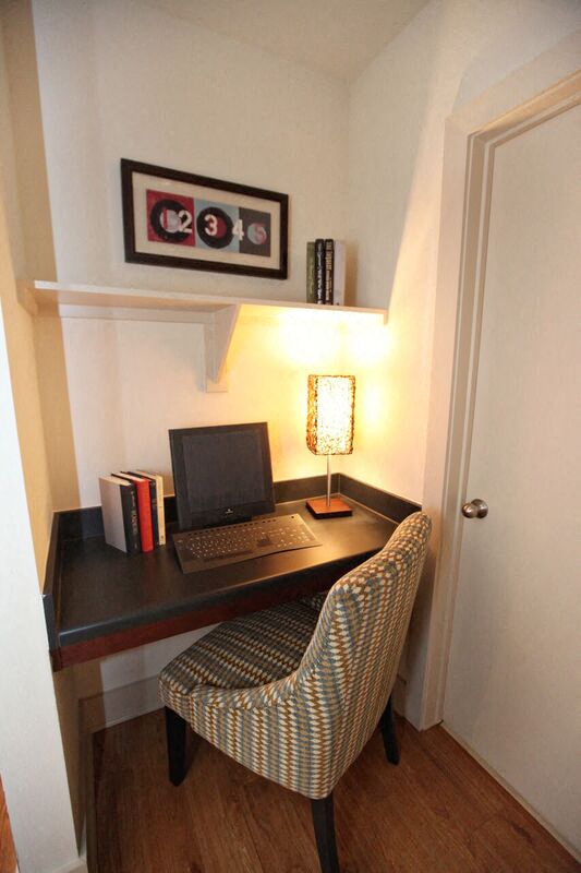 a desk with a laptop and a chair in a room