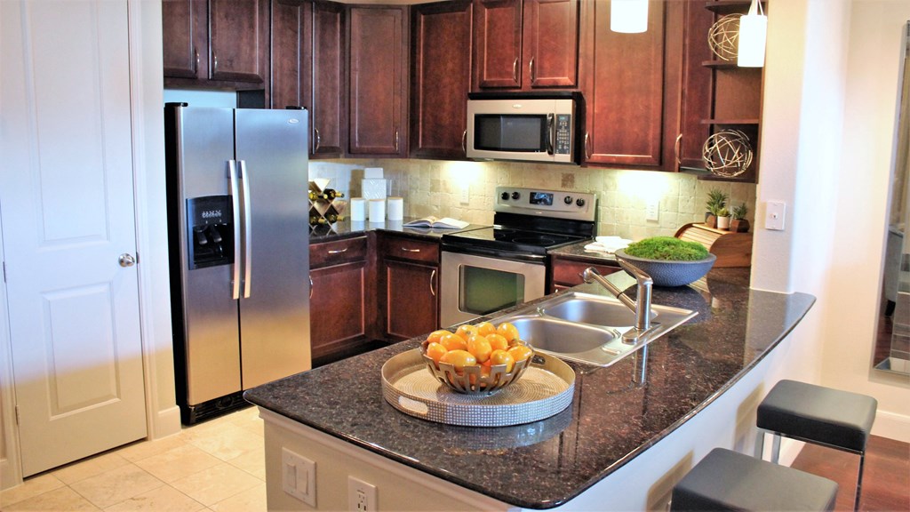 a kitchen with stainless steel appliances and granite counter tops