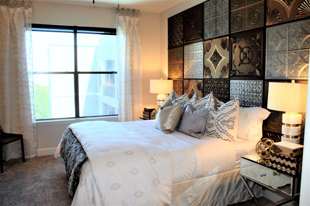 a bedroom with a bed with white sheets and pillows