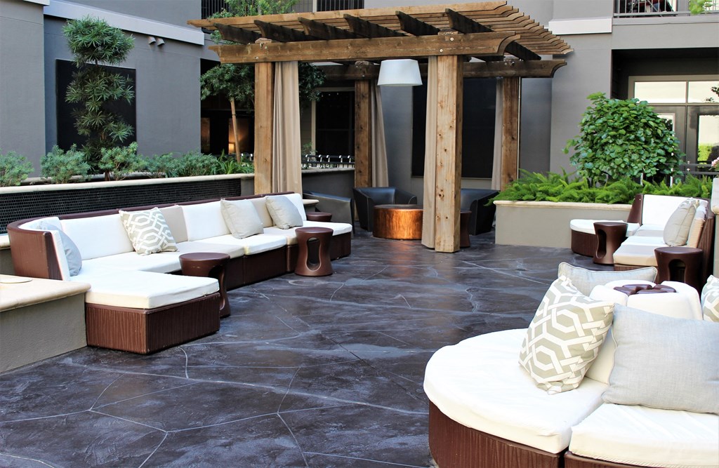 a lounge area with couches and tables in a courtyard