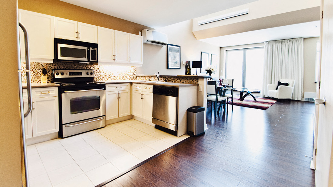 A kitchen with white cabinets and a black stove top oven.
