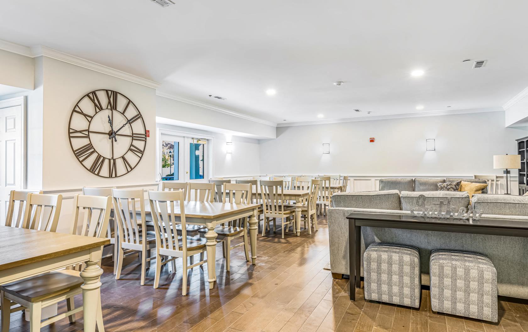 a dining room with tables and chairs and a clock on the wall