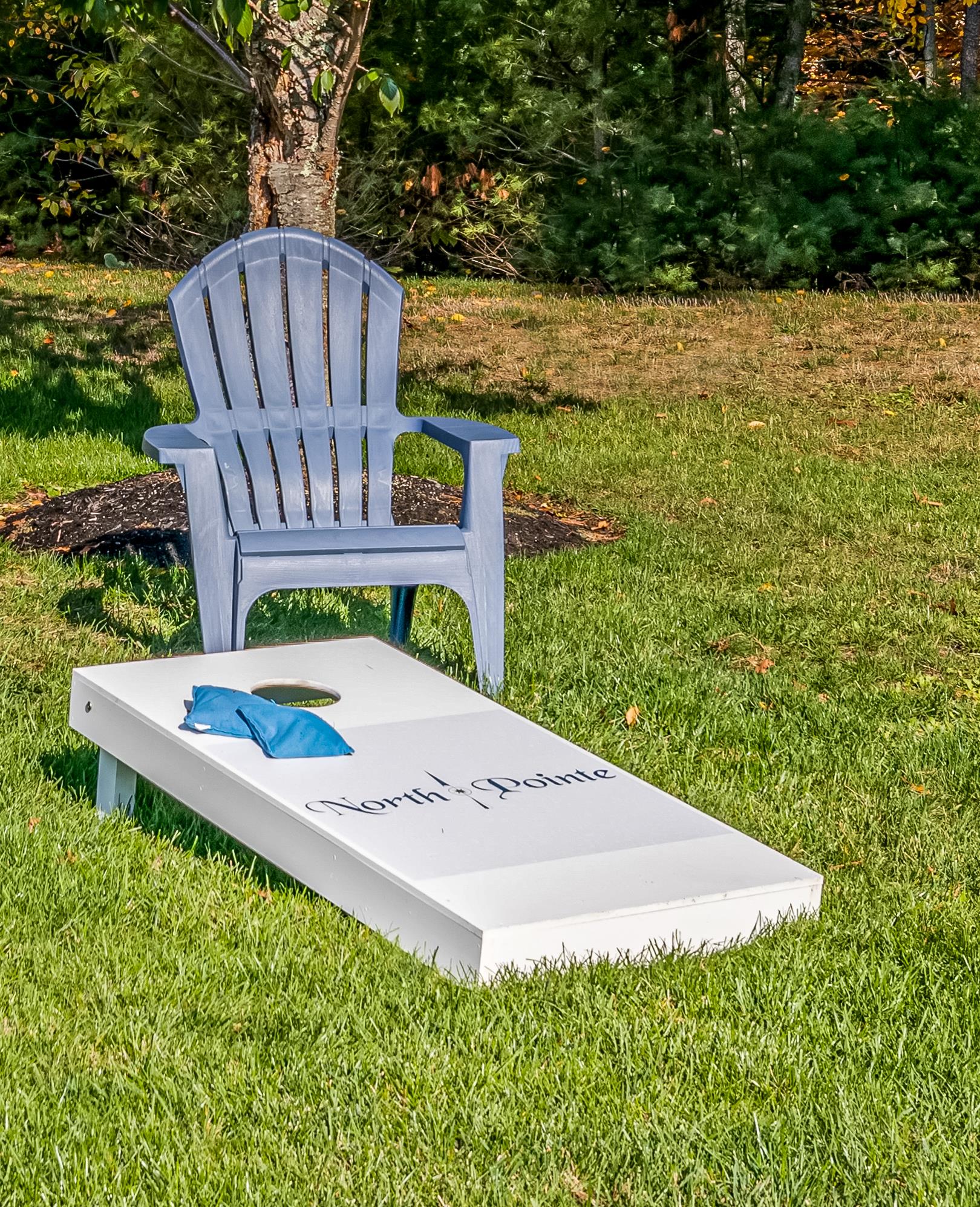 a white box sitting on the grass next to a blue chair