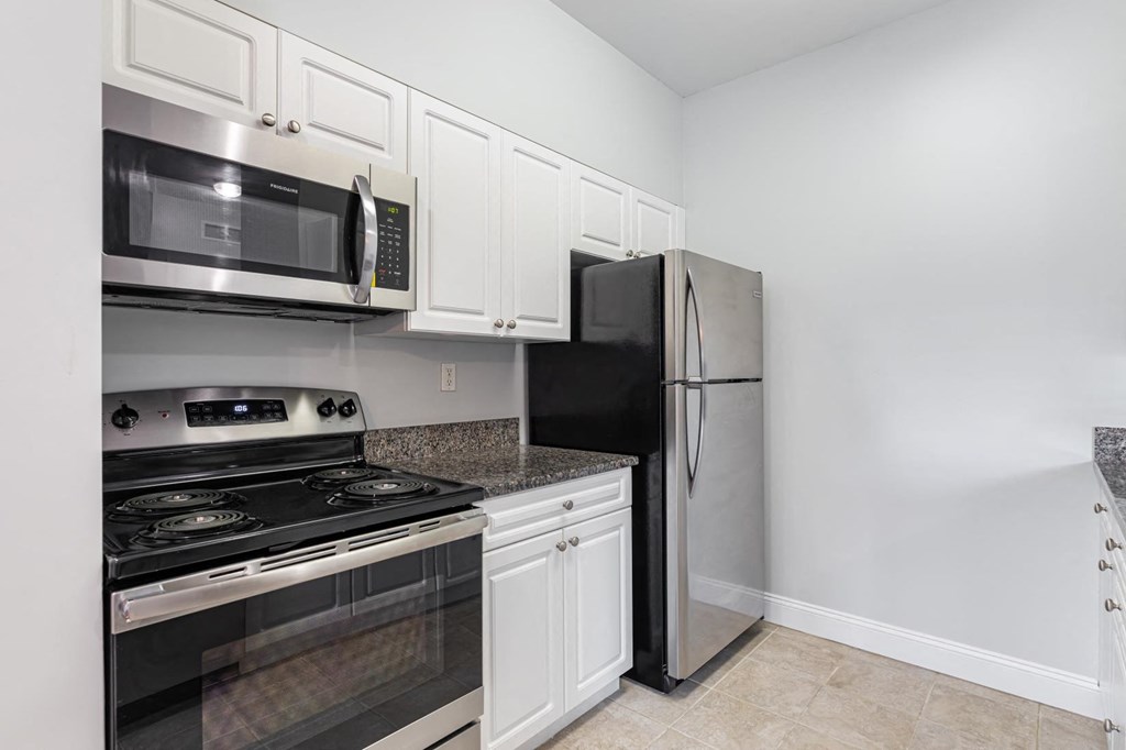 a kitchen with black appliances and white cabinets