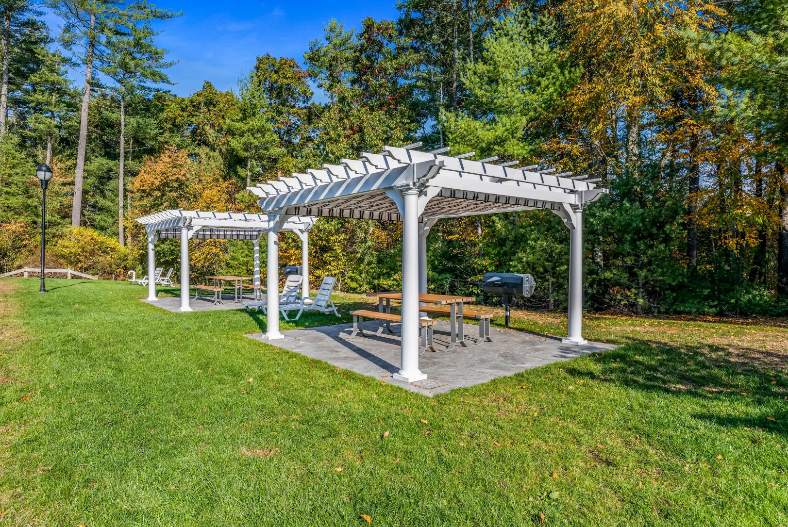a pavilion with a picnic table and a grill in a yard