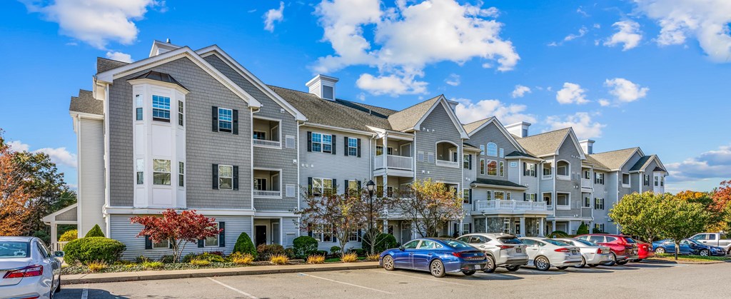 a row of apartment buildings with cars parked in front of them