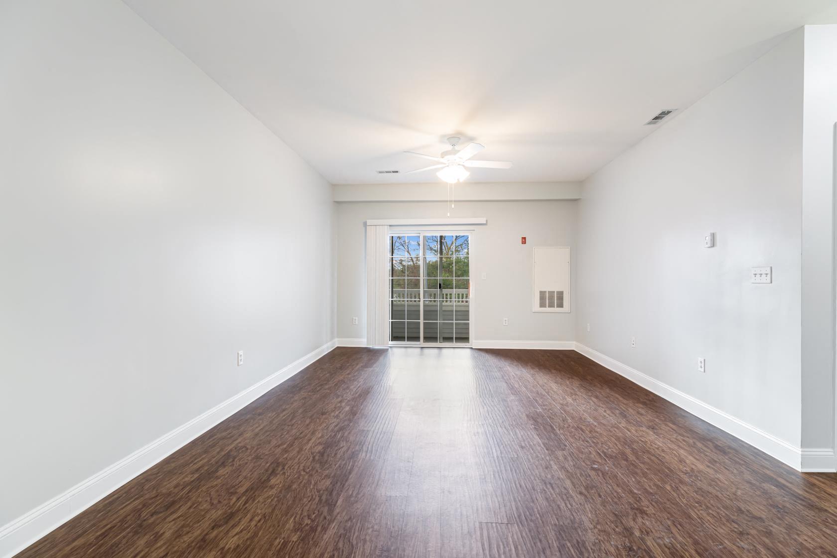an empty living room with white walls and wood floors