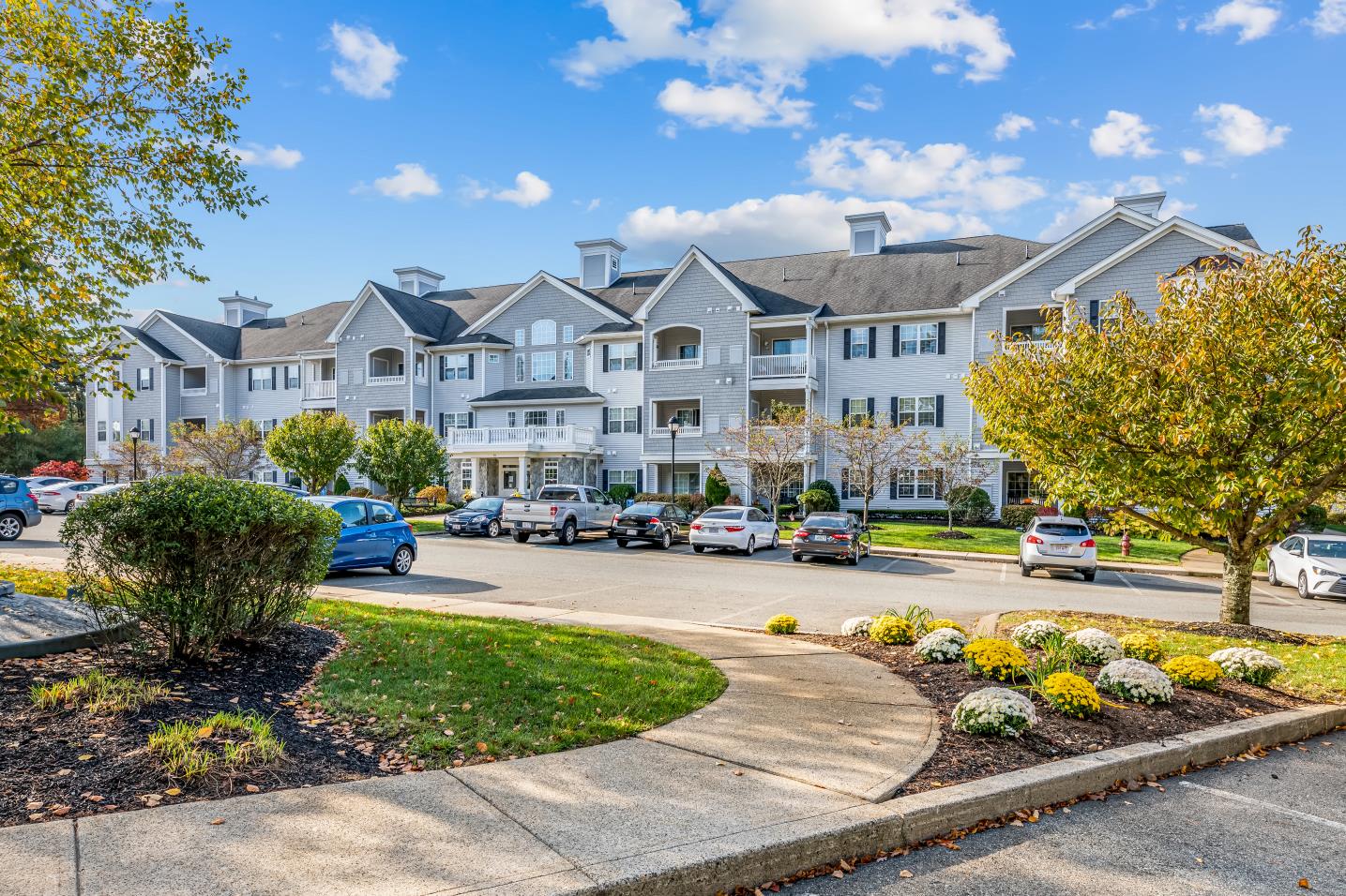 an apartment building with cars parked in front of it