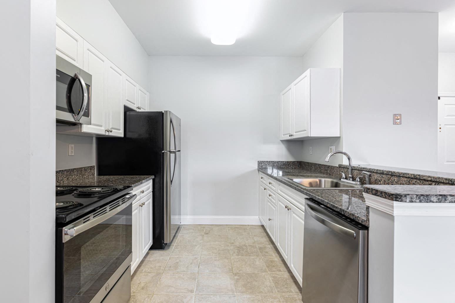 a kitchen with white cabinets and stainless steel appliances