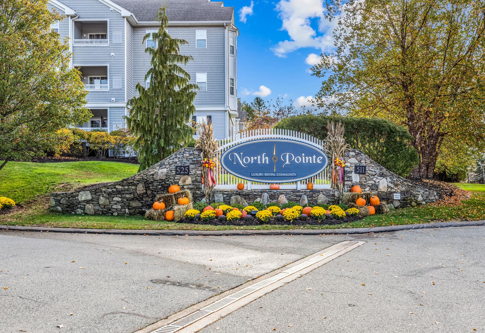 the sign for north pointe at the entrance to a street with pumpkins on