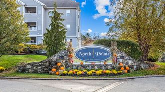 the sign for north pointe at the entrance to a street with pumpkins on
