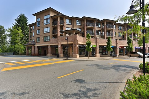 A large apartment building with a parking lot in front.