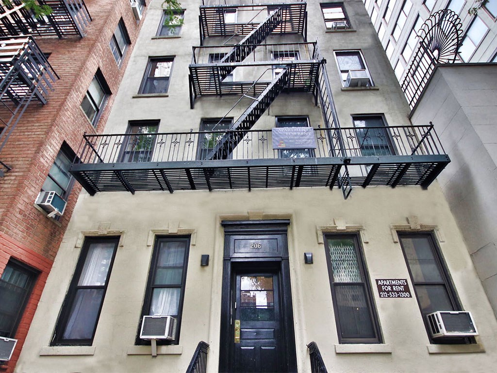 an apartment building with two balconies and a black door
