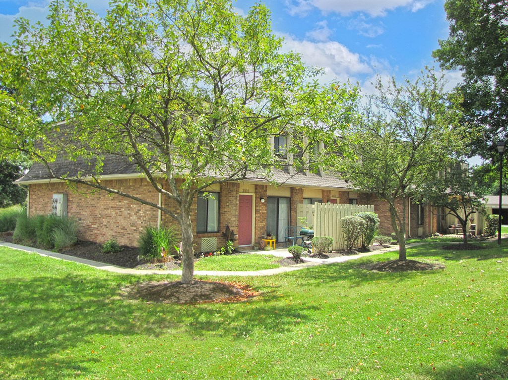 the front of a brick house with trees