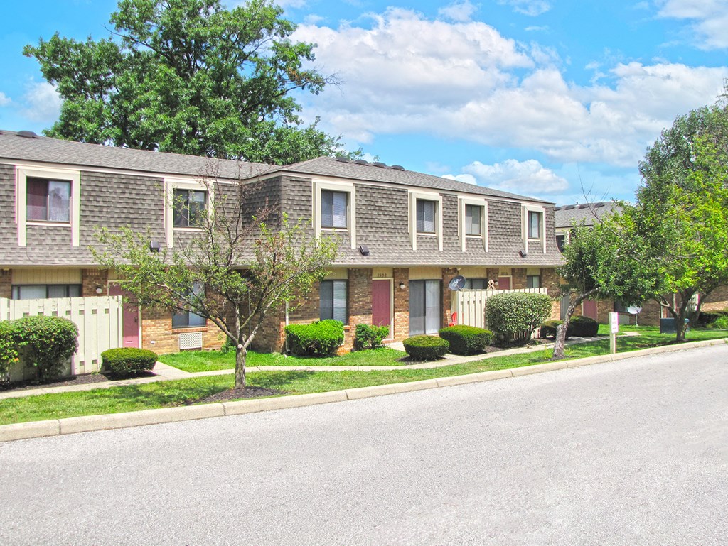 a row of brick apartment buildings on the side of a street