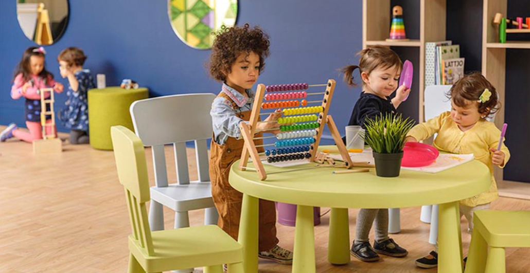 a group of children playing at a table with an abacus