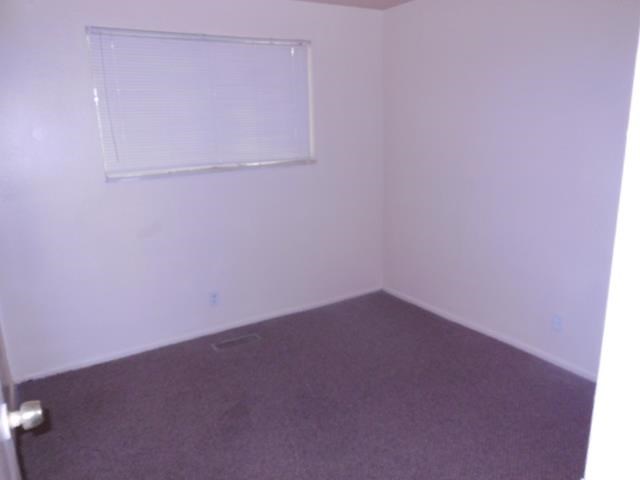 an empty room with a window and a carpet