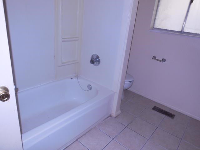 a white bathroom with a tub and a toilet