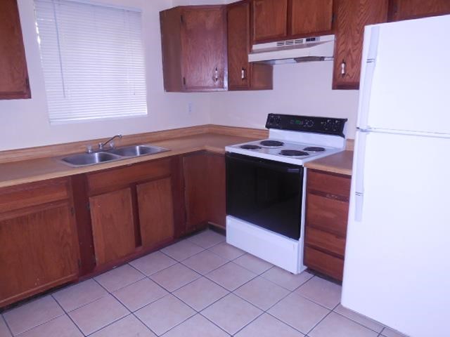 a kitchen with a stove and a sink and a refrigerator
