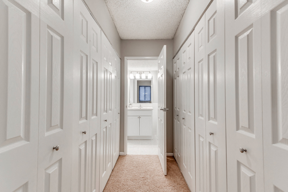 In between two rows of closets with a bathroom at the end of the hall