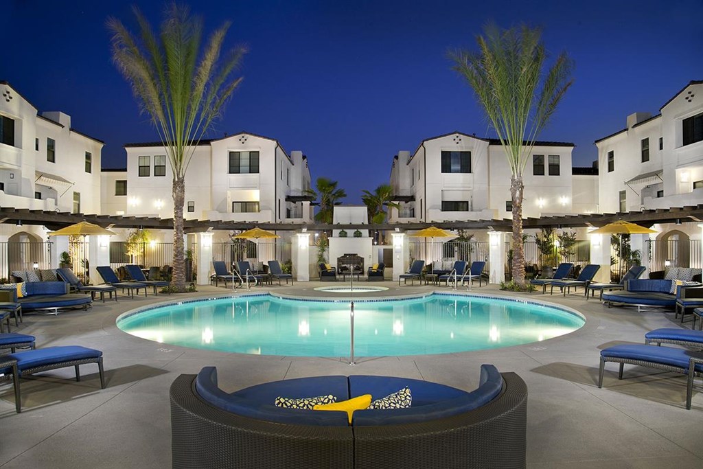 a swimming pool at night at a resort with apartments