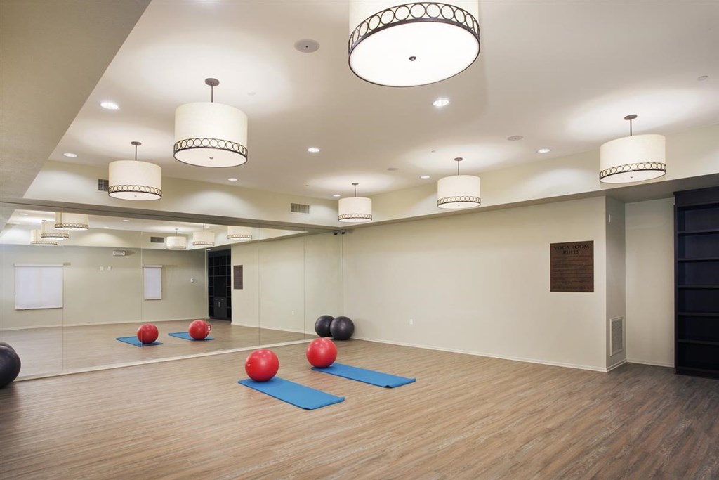 a spacious yoga room with red balls and yoga mats