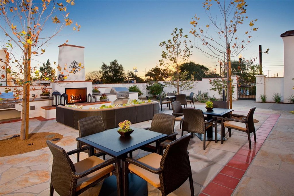 a patio with tables and chairs and a fire pit