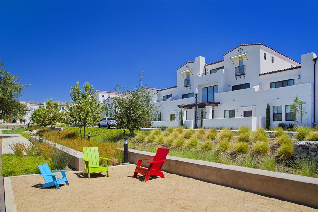 a patio with colorful chairs in front of a building