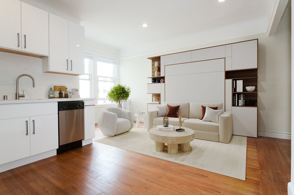 A modern kitchen with white cabinets and a wooden floor.