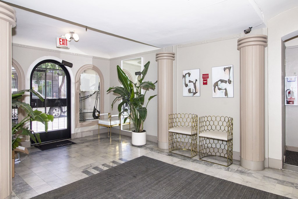A white chair with a gold frame is in the middle of a room.